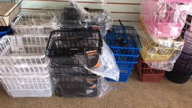 A variety of plastic baskets are sitting in a store.